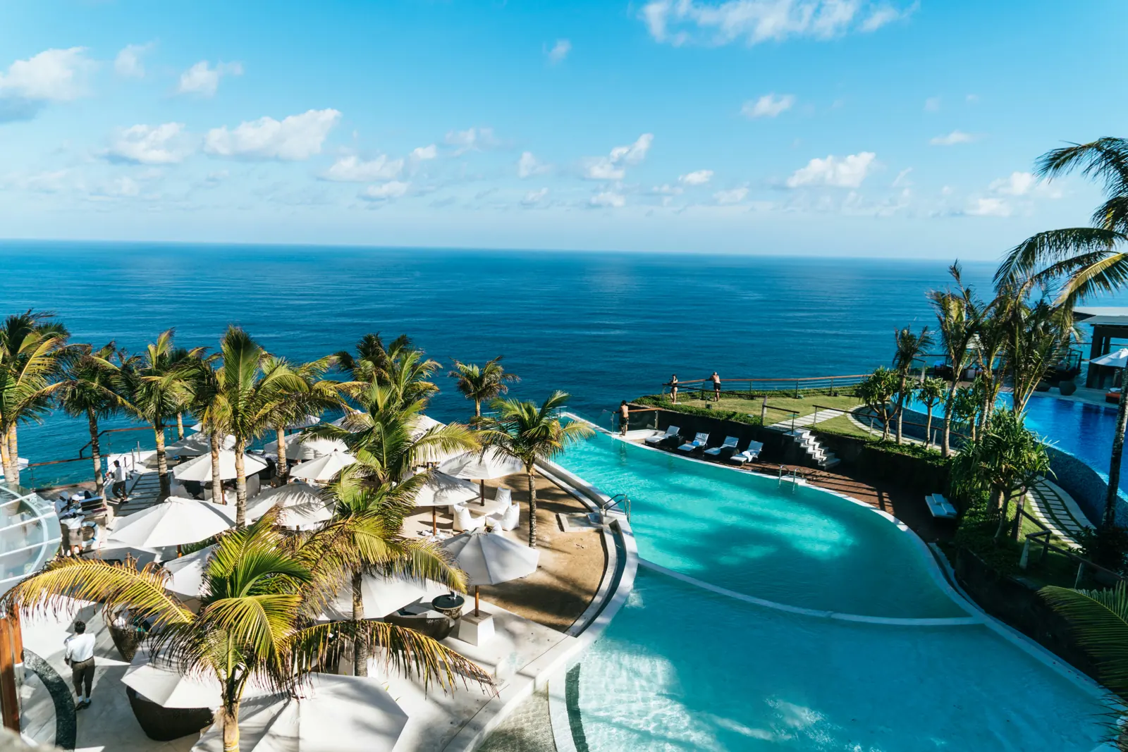 Clifftop infinity pool overlooking a tropical ocean at golden hour